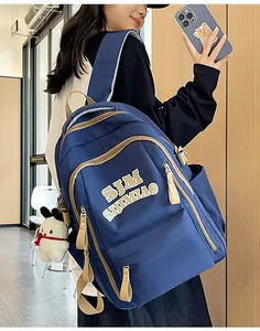 Detail of navy nylon backpack showing spacious compartments and plush puppy charm
