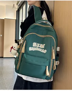 Detail of dark green nylon backpack featuring contrast straps and plush puppy charm