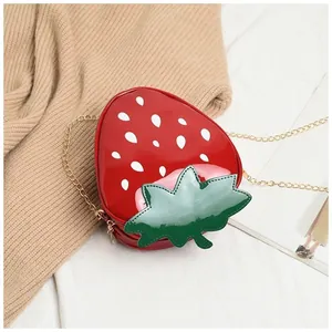 Détail du sac à bandoulière fraise 3D avec feuilles vertes et chaîne métallique