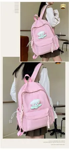 Détail d'un sac à dos en nylon rose avec pendentif ours et cordon de serrage latéral