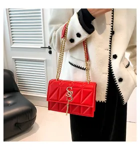 Dettaglio della borsa trapuntata rossa con catena dorata e logo SS in metallo