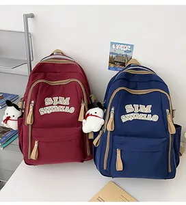 Detail of burgundy and navy school backpacks with SJM SIJIMIAO embroidery and snowman charms