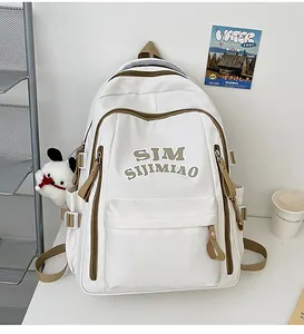 Detail of Korean style cream backpack with brown straps and cute plush dog keychain charm