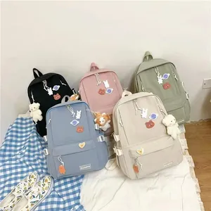 Mochilas escolares minimalistas en cinco colores con lindos parches de dibujos