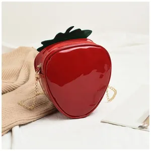 Vue détaillée du sac fraise 3D avec finition rouge brillante et détail de feuille verte