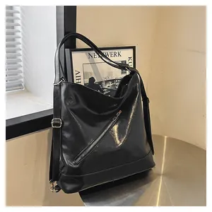 Detalle del bolso hobo de cuero brillante negro con cremallera y hebilla dorada