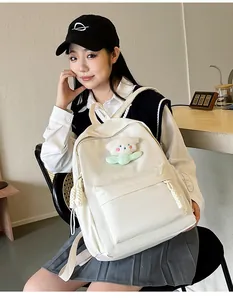 Sac à dos blanc minimaliste avec charme en peluche et détails de fermeture tissés