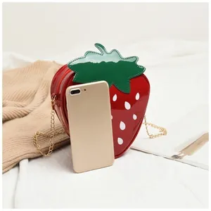 Vue détaillée du sac fraise rouge montrant sa taille compacte à côté d'un smartphone