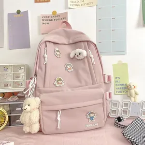 Vista detallada de mochila de nailon rosa con colgantes de oso y diseño funcional