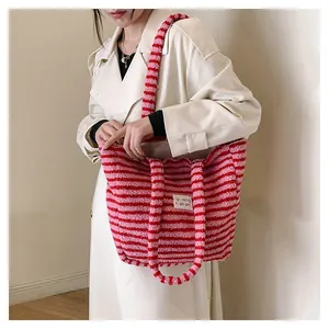 Dettaglio della borsa tote in peluche a righe rosse e rosa con materiale soffice e etichetta