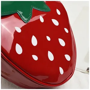 Gros plan d'un sac fraise en cuir verni brillant avec des détails de graines blanches