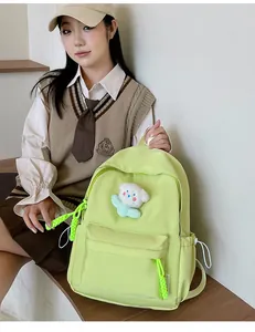 Sac à dos en nylon vert fluo sur modèle avec charme fleur en peluche et cordons tressés