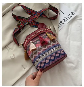 Dettaglio della borsa a secchiello etnica con motivi tessuti colorati e nappe