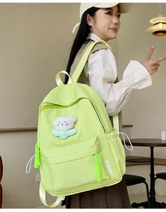 Détail du sac à dos en nylon vert fluo avec pendentif en peluche et étiquette latérale