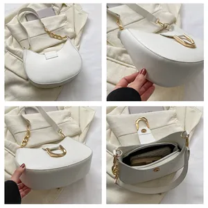 Detail view of cream crescent bag with gold chain strap and spacious inner capacity