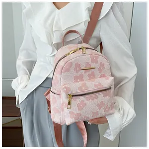 Detailed shot of pink floral mini backpack with gold hardware and zipper on model