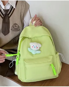Détail du sac à dos en nylon vert clair avec ours en peluche blanc et fermetures éclair vertes