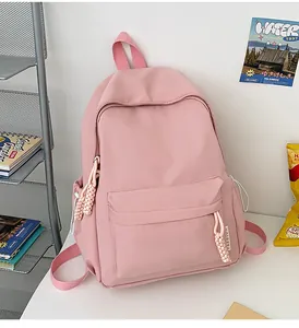 Sac à dos en nylon rose avec poche avant zippée et détail de breloque en corde tissée