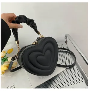 Fashionable heart-shaped crossbody bag in black with quilted pattern and ruched handle