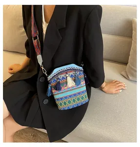 Dettaglio borsa a secchiello in maglia colorata con lunghe frange e tracolla boho