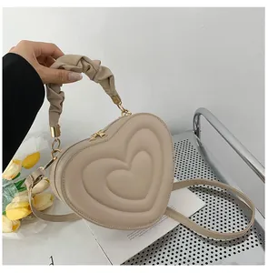 Minimalist beige heart-shaped quilted handbag with gathered handle and gold hardware