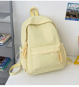 Détail du sac à dos en nylon beige avec compartiment principal et tirette de zip tissée