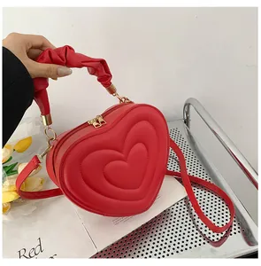 Chic red heart shaped handbag in faux leather with 3D embossed pattern and gold metal zipper