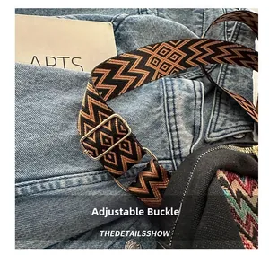 Close-up of adjustable woven shoulder strap with ethnic patterns and gold buckle