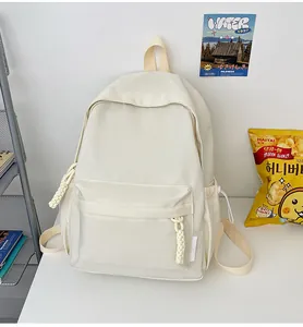 Vue de face d'un sac à dos minimaliste en toile crème avec fermetures éclair et poches de côté