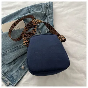 Detail of navy blue canvas bag with ethnic patterned bohemian woven wide shoulder strap