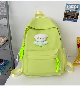 Détail d'un sac à dos en nylon vert fluo avec écusson ours en peluche et sangles jaunes