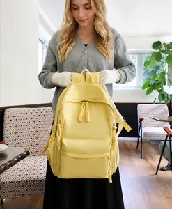 Detail of bright yellow waterproof nylon backpack with braided rope zipper pull features