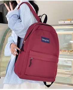 Dunkelroter Nylon-Rucksack für Studenten in einem Lifestyle-Bäcker-Setting mit Markenlogo