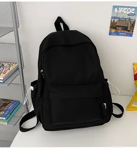 Détail du sac à dos en nylon noir avec tirettes tissées et cordons de serrage latéraux