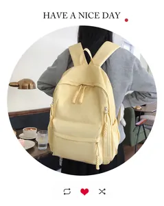 Detail of yellow nylon backpack featuring long woven zipper pulls and side pockets