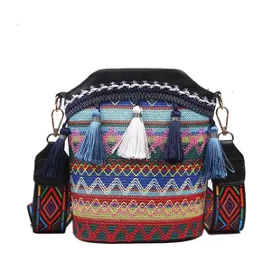 Borsa a secchiello etnica con motivi geometrici e vivaci nappe colorate