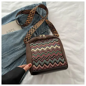 Close-up of ethnic crossbody bag with wave pattern weaving and wide jacquard strap