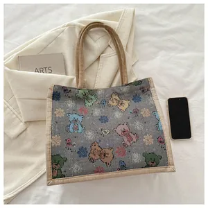 Détail du sac cabas en toile grise avec motifs ours colorés et poignées en lin
