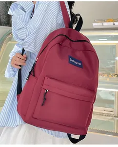 Nahaufnahme eines weinroten minimalistischen Rucksacks, getragen von einem Modell