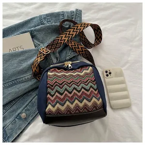 Detail of bohemian crossbody bag with colorful geometric embroidery and canvas leather texture