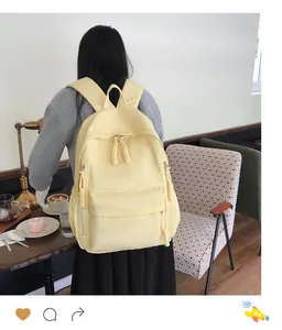 Pale yellow Harajuku style school backpack with large front zipper pocket on a model