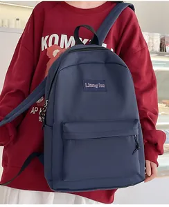 Detailansicht des dunkelblauen Nylon-Rucksacks mit mehreren Taschen, getragen am Modell