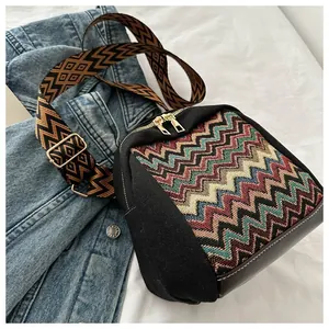 Detail of colorful wave knit fabric, wide shoulder strap and gold zipper on crossbody bag