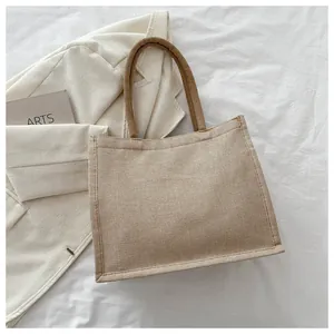 Détail d'un sac cabas en lin minimaliste avec poignées en corde sur fond texturé