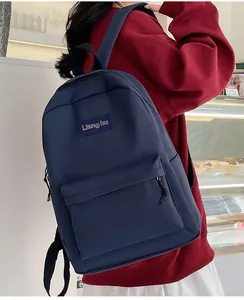 Rückansicht eines marineblauen, minimalistischen Rucksacks mit Logo und Trägern