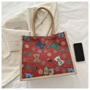 Détail d'un cabas en jacquard rouge foncé avec motifs d'ours et de flocons de neige