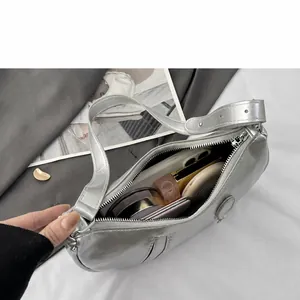 Interior view of the silver crescent bag showing capacity for phone and cosmetics