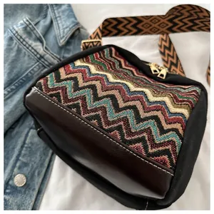 Detail of retro zigzag knit crossbody bag with dark brown leather and golden hardware