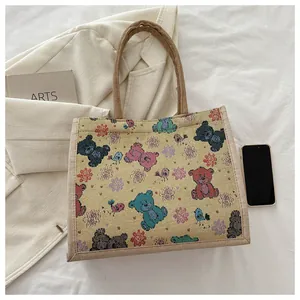 Détail du sac fourre-tout en toile montrant le lin texturé avec des motifs d'ours colorés