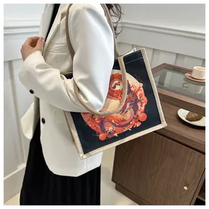 Detail of black canvas tote bag featuring traditional dragon print and rope handles